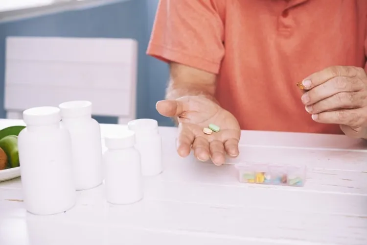 Person sortiert Tabletten in eine Wochenbox