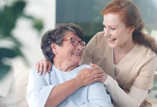 Pflegekraft im Gespräch mit einer Seniorin